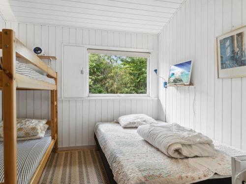 a bedroom with a bunk bed and a window at Holiday Home Zoya - 470m from the sea by Interhome in Gedser