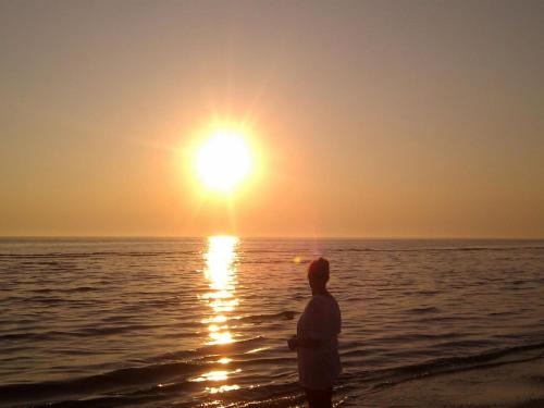 a man standing on the beach watching the sunset at Apartment Werna - 800m from the sea by Interhome in Bjerregård