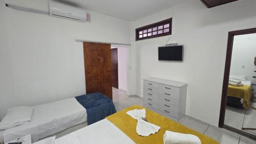 a bedroom with a bed and a dresser and a mirror at Pousada Terra Do Sol in Arraial do Cabo