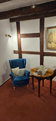 a living room with a blue chair and a table at Hotel Zum Schloss in Quedlinburg