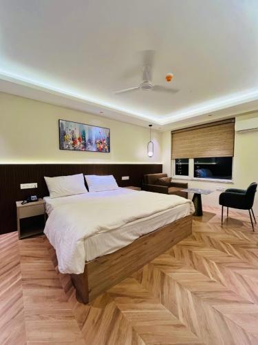 a bedroom with a large bed and a desk at Serenity Suites in Greater Noida