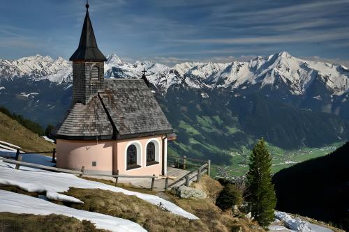 a small church on the side of a snow covered mountain at Apart Mia in Grossried