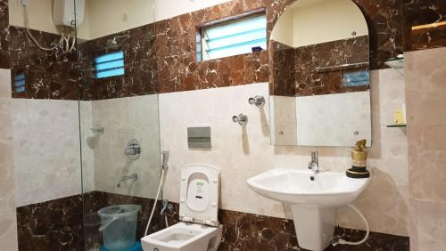 a bathroom with a sink and a toilet at JEEVAN SANDHYA in Puri