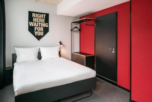 a bedroom with a bed and a red door at The Social Hub Berlin Alexanderplatz in Berlin