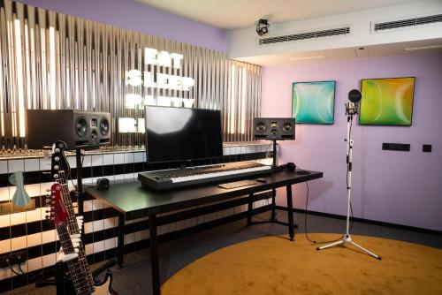 a room with a desk with a keyboard and speakers at The Social Hub Berlin Alexanderplatz in Berlin