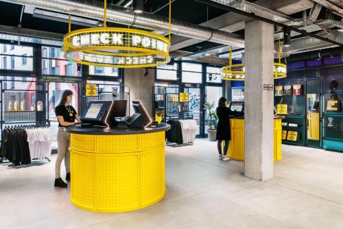 a store with yellow counters and people standing in the store at The Social Hub Berlin Alexanderplatz in Berlin