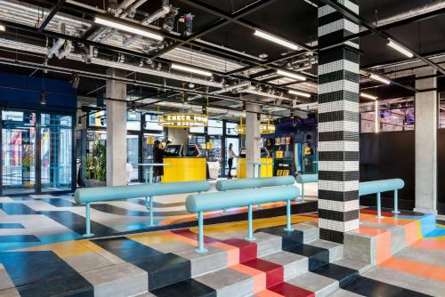 a lobby with blue benches on a colorful floor at The Social Hub Berlin Alexanderplatz in Berlin