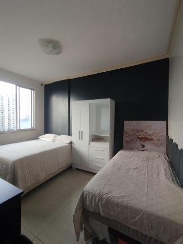a bedroom with two beds and a black wall at Nosso lar in Belém