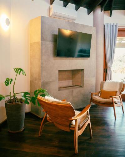 a living room with two chairs and a fireplace at Atiaia Jungle River Retreat in Visconde De Maua
