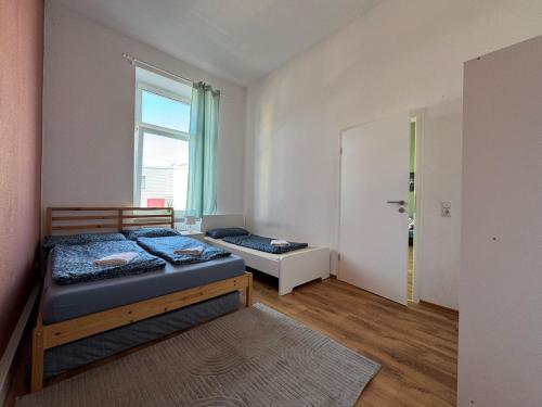 Un dormitorio con dos camas y una ventana. en 4YOU Appartement Ferien & Monteursunterkunft, en Wuppertal