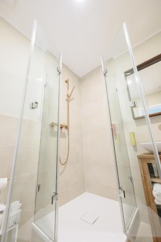a bathroom with a glass shower stall at Boutiquehotel Kloster Pfalzel in Trier
