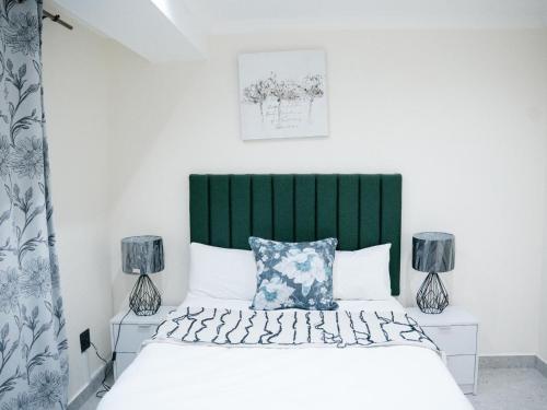 Un dormitorio con una cama con cabecero verde. en Bokwe Guesthouse - Gordons Bay, en Gordonʼs Bay