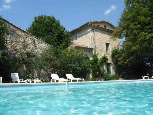 a house with a swimming pool and white chairs at Appartement 1 in Montboucher-sur-Jabron