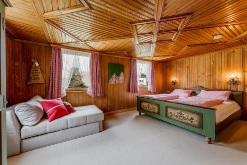 a bedroom with two beds and a couch in it at Uriges Haus im Grünen in Grünenbach