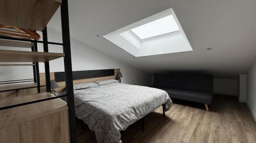 a bedroom with a bed and a skylight at Casa Florida Hernani in Hernani