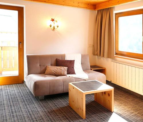 a living room with a couch and a coffee table at Apart Gabriele - Pure Alpin Style in Sankt Anton am Arlberg