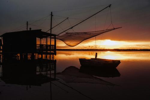 a boat sitting in the water at sunset at al n.10 BnB in Ravenna