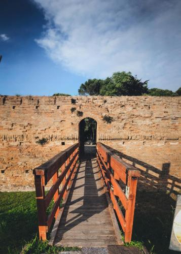 a wooden bridge over a brick wall with a tunnel at al n.10 BnB in Ravenna