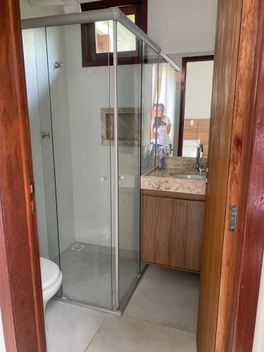 a bathroom with a glass shower and a toilet at Águas da Serra Condomínio in Bananeiras