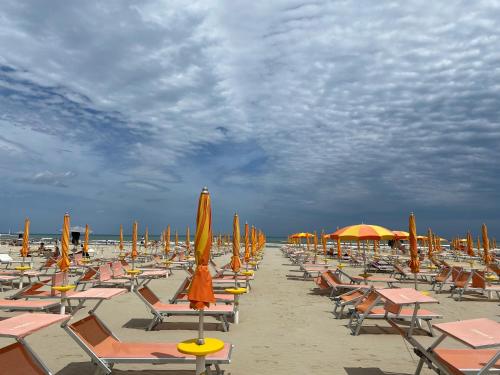 a bunch of chairs and umbrellas on a beach at al n.10 BnB in Ravenna