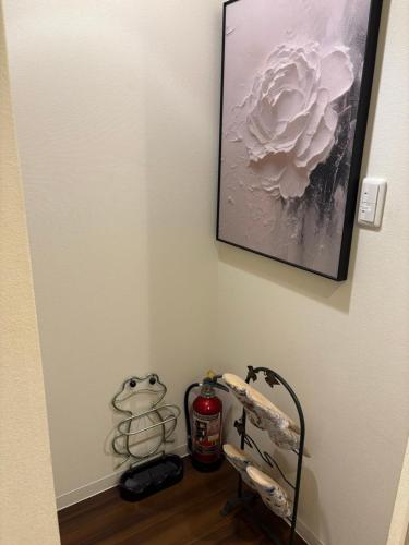 a room with a wall with a picture of a flower at 国慶節 大手町 23分 ディズニー Disney 羽田空港 リムジンバス 東部地域病院まで徒歩1分 成田空港 in Tokyo