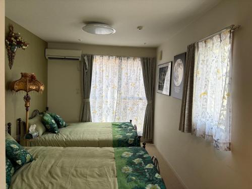 a bedroom with two beds and a window at 国慶節 大手町 23分 ディズニー Disney 羽田空港 リムジンバス 東部地域病院まで徒歩1分 成田空港 in Tokyo