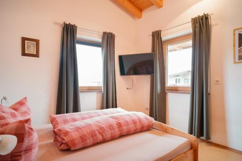 a room with a couch and a tv and windows at Appartement Resi in Achensee