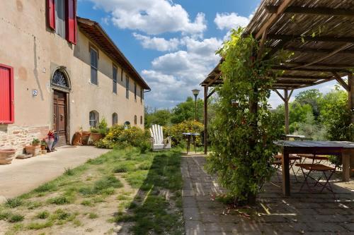 a garden with a table and a building at Fattoria le Caprine in Querce