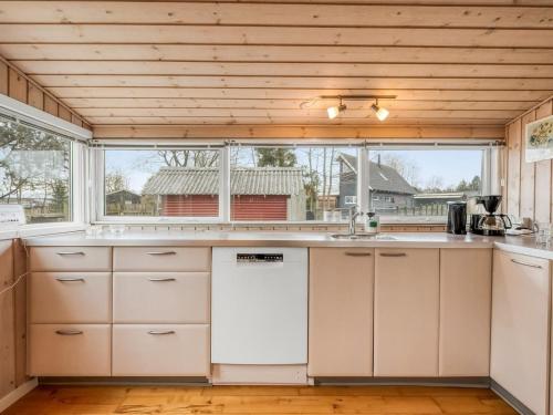 a kitchen with white cabinets and a large window at Holiday Home Bosi - 100m to the inlet by Interhome in Højslev
