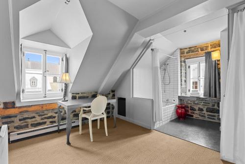 a white room with a table and a chair at Auberge Place d'Armes in Quebec City