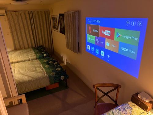 a room with a bed and a tv on the wall at 国慶節 大手町 23分 ディズニー Disney 羽田空港 リムジンバス 東部地域病院まで徒歩1分 成田空港 in Tokyo