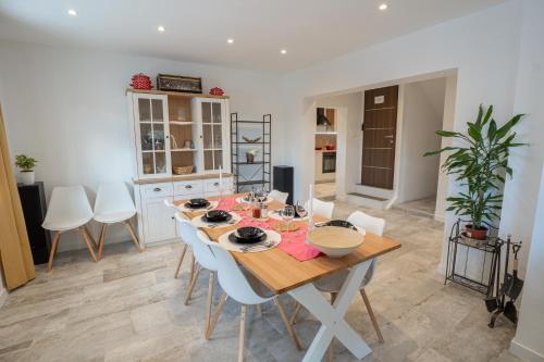 a dining room with a wooden table and white chairs at Cosy home D&D in Brod Moravice