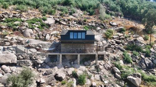 a house on top of a rocky mountain at Gardunha Stone in Louriçal do Campo