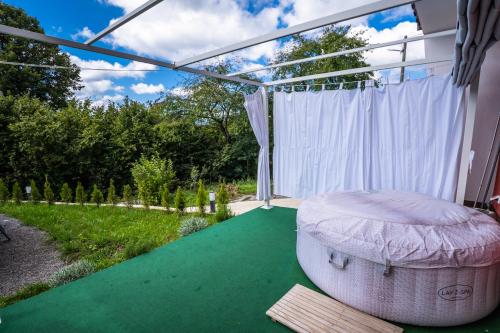 a pergola with a bed on a green porch at Cosy home D&D in Brod Moravice