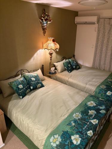 two beds sitting next to each other in a bedroom at 国慶節 大手町 23分 ディズニー Disney 羽田空港 リムジンバス 東部地域病院まで徒歩1分 成田空港 in Tokyo