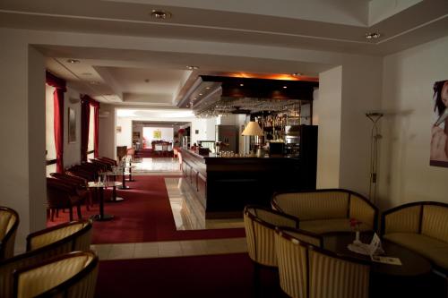 bar w restauracji z krzesłami i ladą w obiekcie Grand Hotel Strand w Drużbakach Wyżnych
