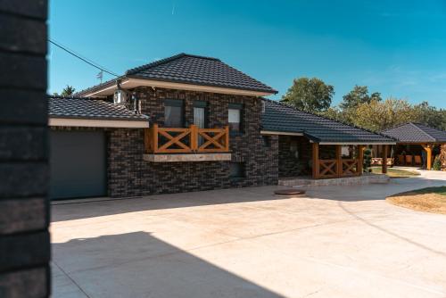 a brick house with a garage and a driveway at casa lumina in Gročanska Ada