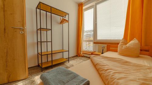 a bedroom with a bed and a window with orange curtains at Vila Familia in Turčianske Teplice