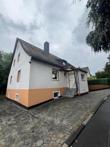 a small white house with stairs on a street at Ferienhaus Hörbach - Die kleine Auszeit in Herborn