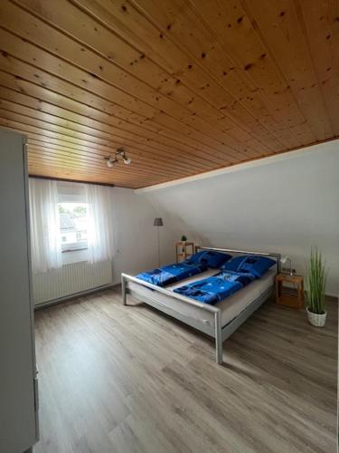a bedroom with a large bed with a wooden ceiling at Ferienhaus Hörbach - Die kleine Auszeit in Herborn