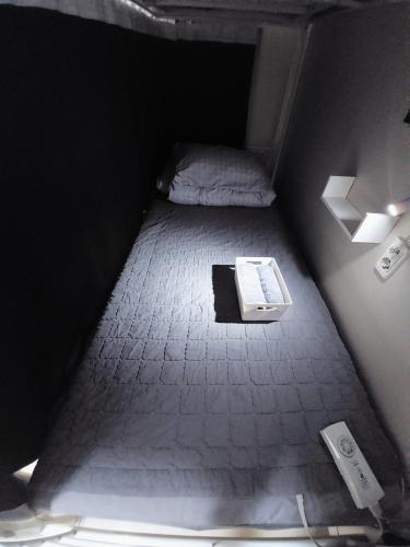 釜山にあるFUNWAVE guest houseのベッドと床にノートパソコンが置かれた小さな部屋