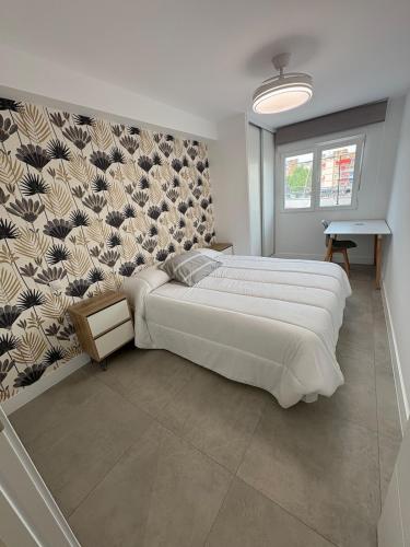 a bedroom with a large bed and a wall at Apartamento en el centro de Móstoles in Madrid