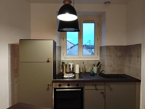 a kitchen with a refrigerator and a window at La Petite Fabrique in Villedieu-sur-Indre