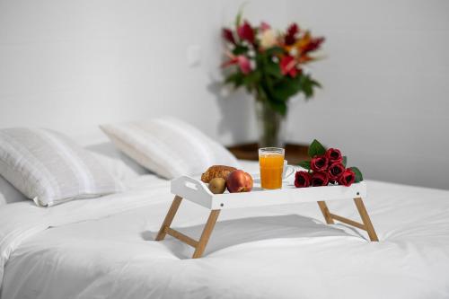 a tray of fruit and orange juice on a bed at Domaine Honore - Case Créole dans Jardin Tropical in Sainte-Rose