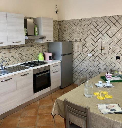 a kitchen with a table and a refrigerator at BeB Lucky House Francesca in Scafati