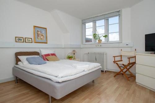 a bedroom with a bed and a television in it at Villa Gertrud - Bed & Breakfast in Kolding