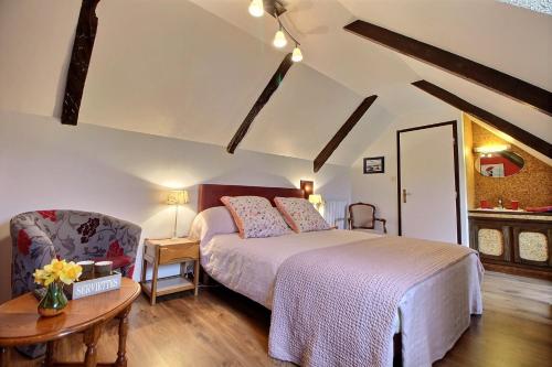 a bedroom with a bed and a chair and a table at Gîte De Kerberso in Pléhédel