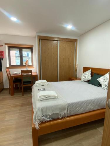 Un dormitorio con una cama grande y una mesa. en Quinta do Azibo Studios Bragança, en Bragança