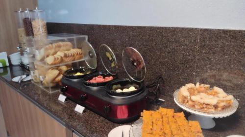 a kitchen counter with a buffet of food and bread at Pousada São Gerônimo in Matinhos