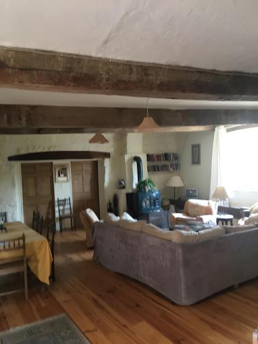 a living room with a large couch and a table at Chez Janie Hirst - Chambres d'hôtes in Montboucher-sur-Jabron